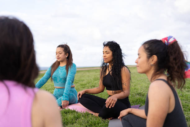 istock Group of women meditating outdoors in a public park 2157412891