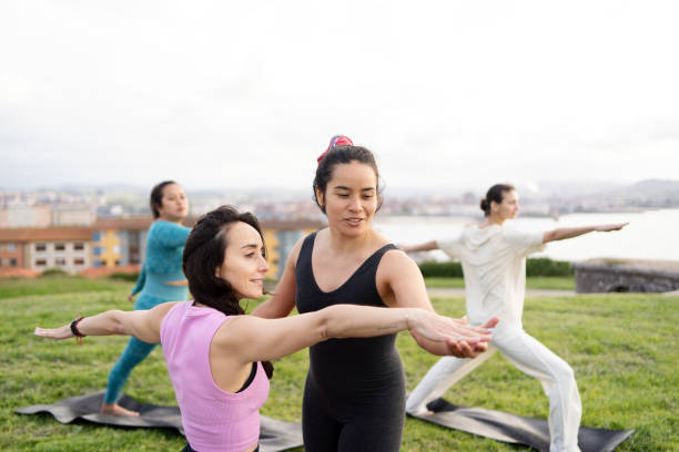 istock Yoga teacher correcting posture of woman doing warrior pose 2157412900