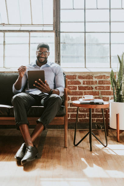 istock Cheerful black man using a stylus with a  digital tablet in a living room 2157414226