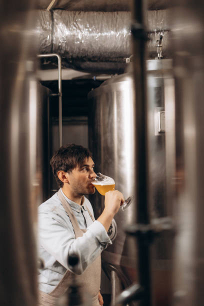 istock Brewery owenr tasting fresh beer and looking interested 2157416318