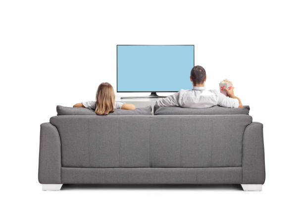 Rear view shot of a man and kid in front of a tv screen with a box of popcorn Rear view shot of a man and kid in front of a tv screen with a box of popcorn isolated on white background couch back stock pictures, royalty-free photos & images