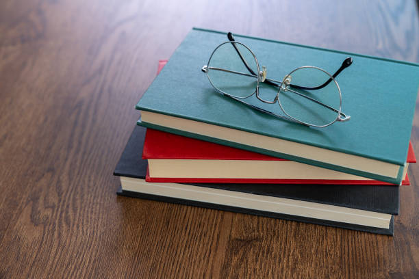 istock Eyeglasses resting on a stack of books 2157417346