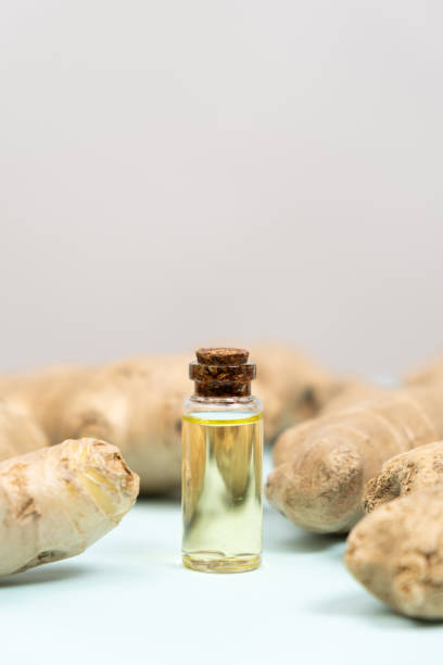 istock Natural ginger oil in glass bottle among ginger root, space for text 2157417618