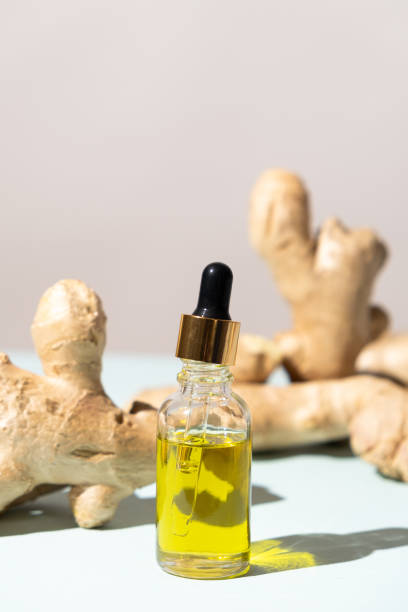 istock Natural ginger oil in glass bottle among ginger root 2157417642