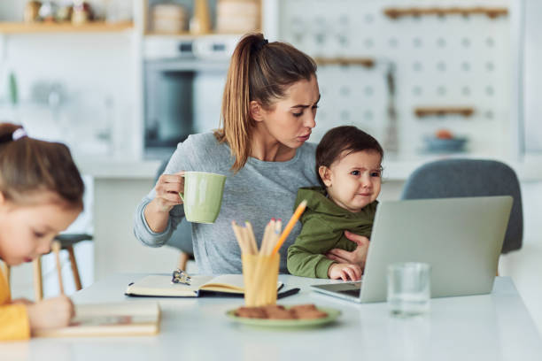 istock A single working mother checking up on her toddler in her arms while working from home 2157421586