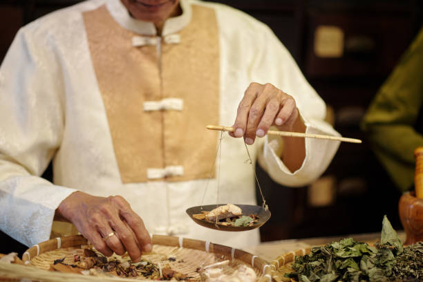 istock Senior Apothecary Measuring Herbs On Scale 2157426631