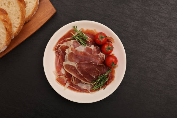 istock Cured ham and mini tomatoes on a plate. 2157428987