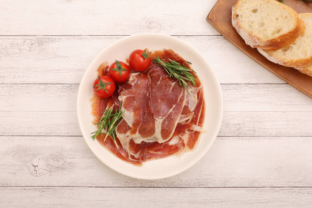 istock Cured ham and mini tomatoes on a plate. 2157428999