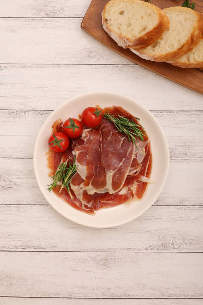 istock Cured ham and mini tomatoes on a plate. 2157429001