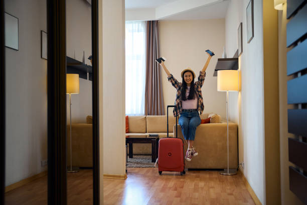 istock Female tourist rejoicing at her arrival at luxury suite 2157434432