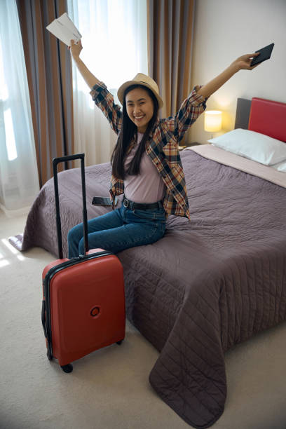 istock Cheerful young female sitting in her luxury suite upon arrival 2157434436