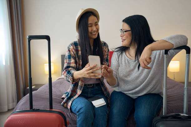 istock Daughter and mother viewing something on cellphone in suite 2157434479