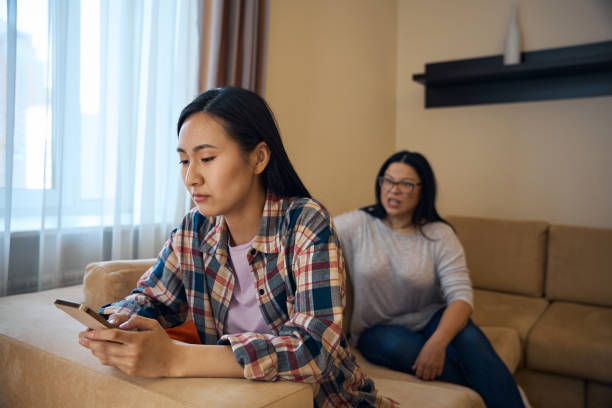 istock Despondent daughter using mobile phone during quarrel with parent 2157434528