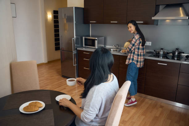istock Joyous young woman making coffee for herself and mother 2157434532