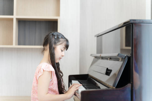 A young girl is playing the piano