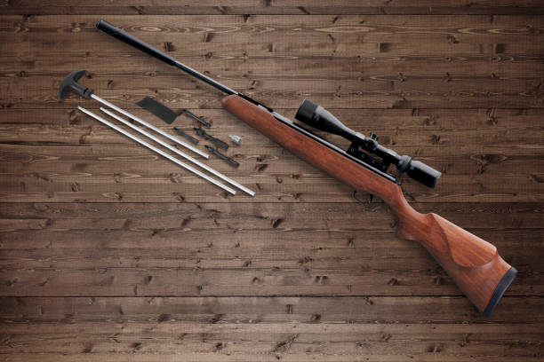 istock Hunting air rifle with rifle cleaning kit on a wood background 2157442082