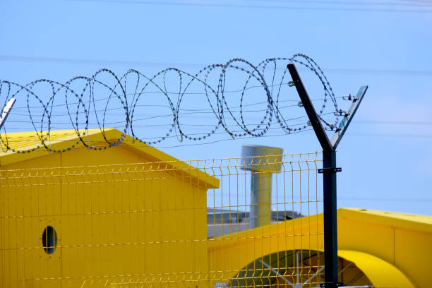 istock Industrial gas equipment is painted yellow behind barbed wire. 2157442130