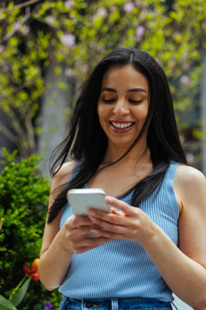 istock Latina with a beautiful smile looking down at her phone 2157444123
