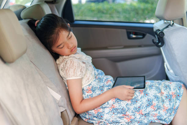 Little girl was playing iPad in the car, tired and asleep