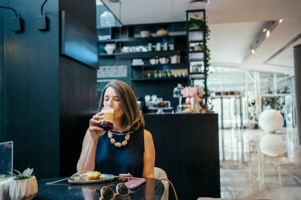 istock Businesswoman using cell phone in hotel cafe 2157445108