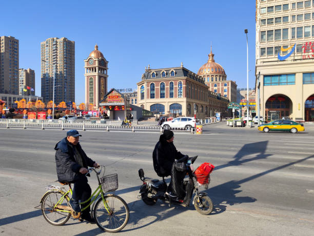 Local people riding bicycles on a main street in Xishi district, Yingkou city, Liaoning, China.