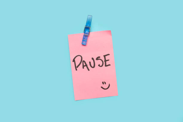 istock Pause word written on a pink sticky paper on a blue background 2157446070