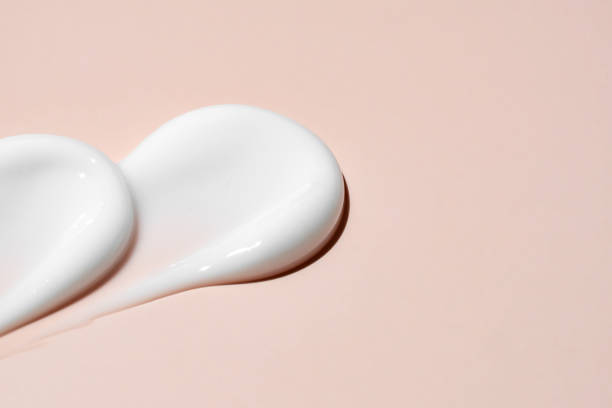 istock White cosmetic face cream or body lotion moisturizer strokes on pastel beige background. Hygiene, skincare product with creamy texture. Beauty face creme smear swatch on color background 2157446910