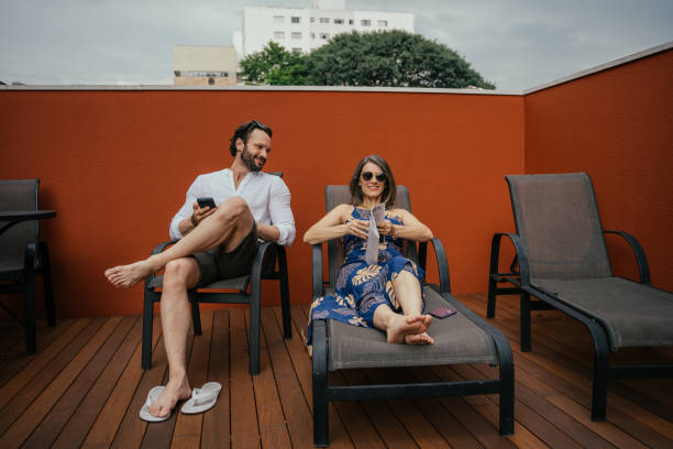 istock Couple sitting on sun lounger around swimming pool in luxury hotel 2157447428