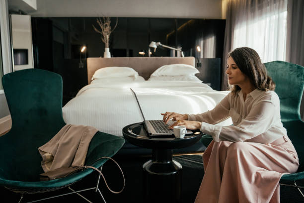 istock Business woman using laptop in hotel room 2157447500