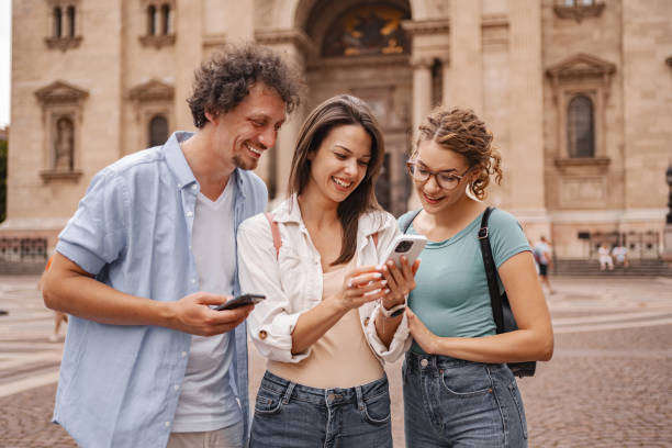 istock Three happy tourists using mobile phone while exploring the city of Budapest 2157453746