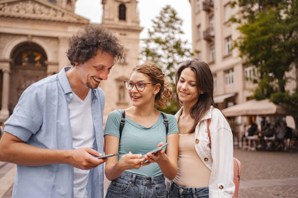 istock Three happy tourists using mobile phone while exploring the city of Budapest 2157454215