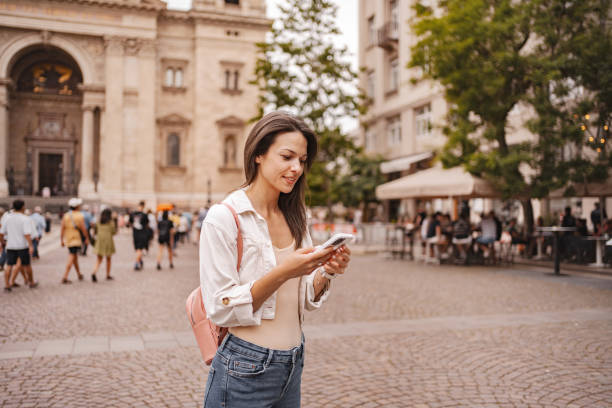 istock Young woman using mobile phone while standing in the Budapest city center 2157459227