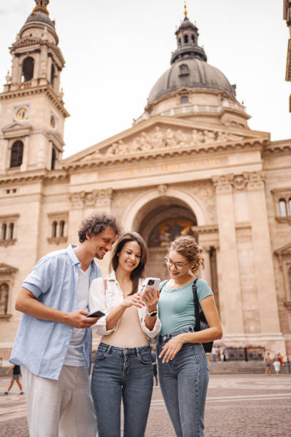 istock Three happy tourists using mobile phone while exploring the city of Budapest 2157459405
