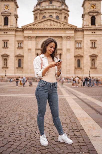 istock Young woman using mobile phone while standing in the Budapest city center 2157459902