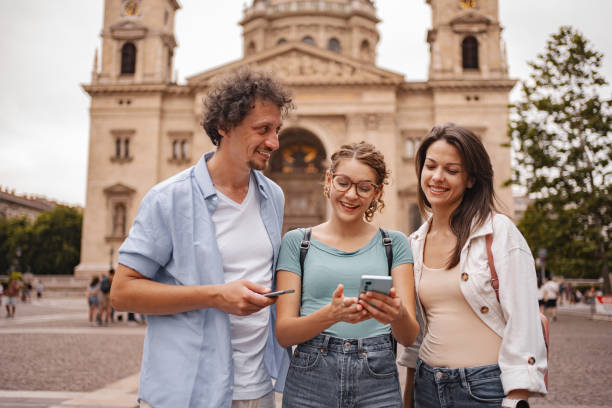 istock Three happy tourists using mobile phone while exploring the city of Budapest 2157459907