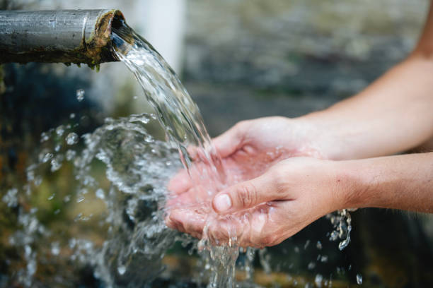 istock Close-up of hands touching water from drinking fountain. 2157463514