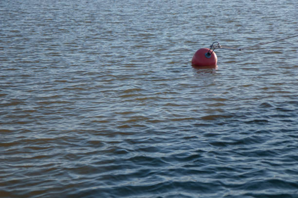 Plastic red buoy on a sea with small waves, Finland, marina