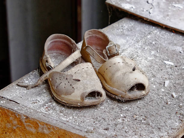 istock A pair of old, worn-out sandals covered in dust. 2157467452