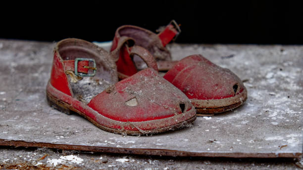 istock A pair of old, red sandals covered in dust are abandoned on a grey surface. 2157467454
