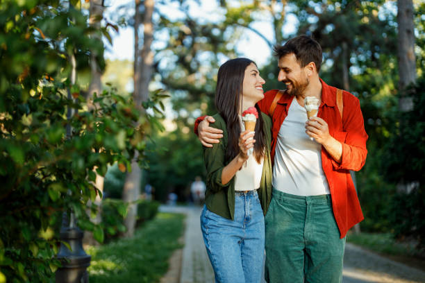 istock Cheerful couple eating ice cream on a sunny path 2157475292