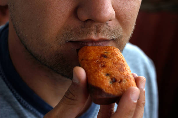 istock man eating a bun, man's mouth biting a bun close-up, nutrition concept 2157476165