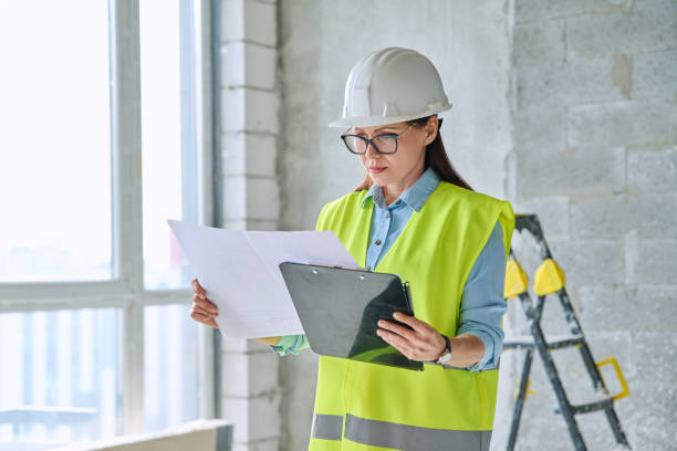 istock Technical profession woman in protective vest helmet working on construction 2157476341