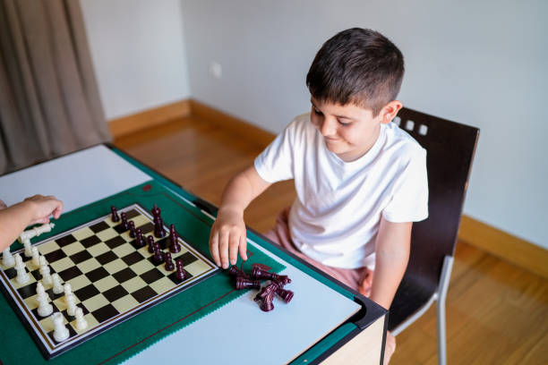 istock A boy is playing a game of chess with another person 2157477944