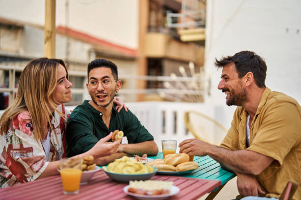 urban roof enjoying sitting male cafe restaurant leisure table friendship boyfriend flirting girlfriend romance dating date meeting girl two romantic conversation casual Happy young people having fun during a rooftop party during a summer holiday, sitting by the table talking, eating and drinking, love, romance, relationship, flirting and youth culture concept Dating girl stock pictures, royalty-free photos & images