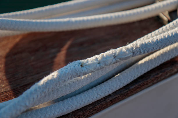Repaired white rope for sailing on yacht deck, stiches, mend, sunlight, close up shot