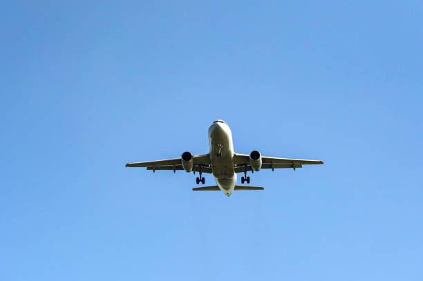istock Holiday jet in flight isolated against a clear blue sky 2157481573