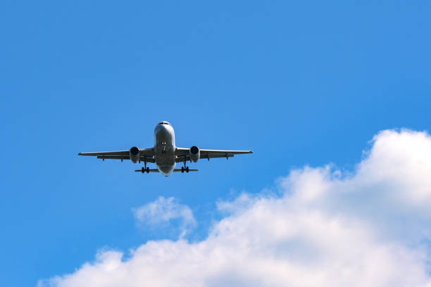 Unmarked holiday jet isolated against a blue sky with white clouds. Travel concept. Copy space.