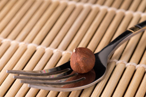 silver fork photographed in close-up on a bamboo mat , macro photo