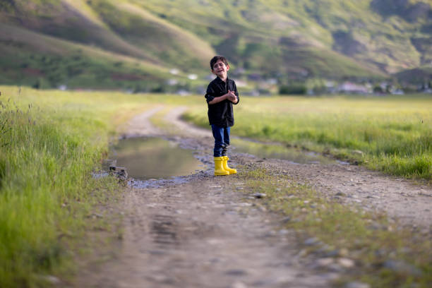 Little boy playing in mud water