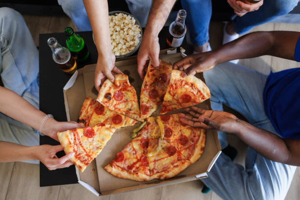 istock Friends eating pepperoni pizza 2157486455